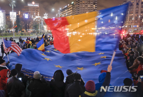 【부카레스트( 루마니아) = AP/뉴시스】 = 루마니아의 부카레스트에서 3일( 현지시간) 고위층 비리 처벌을 완화하는 '사법개악'에 반대하는 시위대가 국기를 흔들며 항의시위를 벌이고 있다. 전국 도시에서 일어나는 시위에 대해 집권 여당은 다음 주에 맞불 시위를 조직하겠다고 예고했다. 