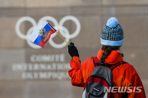 【로잔(스위스)=AP/뉴시스】 국제올림픽위원회(IOC)는 5일(현지시간) 스위스 로잔에서 집행위원회를 열고 내년 평창 동계올림픽에서 러시아 선수들의 개인 출전은 허용하지만 선수단 출장은 금지했다. 이날 러시아 국기를 든 한 여성이 IOC 본부를 바라보고 있다. 2017.12.06. 