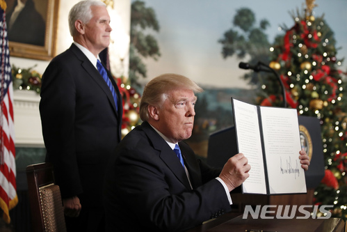 【워싱턴=AP/뉴시스】도널드 트럼프 미국 대통령이 6일(현지시간) 백악관에서 예루살렘을 이스라엘 수도로 공식 인정한다는 내용의 선언문에 서명한 뒤 이를 들어보이고 있다. 2017.12.8. 