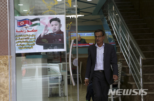 【가자시티=AP/뉴시스】팔레스타인 남성이 14일(현지시간) 가자지구 자발리야 난민촌에 있는 샤와르마 식당에서 나오고 있다. 이 식당의 출입문에는 북한 지도자 김정은의 사진이 있는 포스터가 붙여잇다. 2017.12.15 