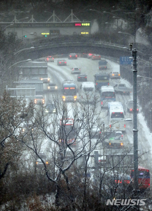 【서울=뉴시스】 장세영 기자=새벽부터 많은 눈이 내리고 있는 18일 서울 중구 남산 1호터널 앞 도로에 차량들이 엉금엉금 언덕을 오르고 있다. 2017.12.18.photothink@newsis.com