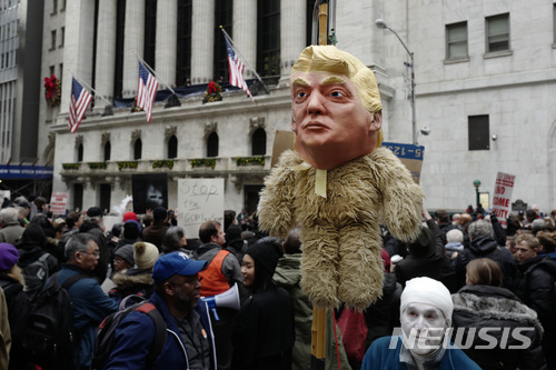 【뉴욕=AP/뉴시스】미국 뉴욕의 증권거래소 앞에서 19일(현지시간) 시민들이 도널드 트럼프 대통령 인형을 세워놓고 세제개편안에 반대하는 시위를 벌이고 있다. 2017.12.20 