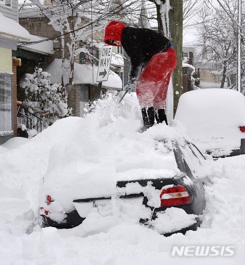 【이리( 미 펜실베이니아주) = AP/뉴시스】미국 펜실베이니아주 이리 시내에서 27일(현지시간) 한 주민이 눈속에 파묻힌 자기 차 위의 눈을 치우고 있다. 이 지역에서는 며칠 동안 165cm의 눈이 쌓여 비상재해지역이 선포되었다. 2017.12.28 