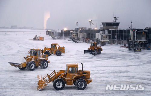 【뉴욕=AP/뉴시스】4일(현지시간) 강력한 눈폭풍과 화이트아웃(시계 상실) 현상으로 항공기 운항이 전면 중단된 뉴욕 라과르디아 공항에서 대형 삽이 달린 트랙터들이 제설 작업을 펼치고 있다. 라과르디아 공항은 후에 운항이 부분 재개됐지만 존 F 케네디 국제공항은 5일 오전 7시(한국시간 오후 9시)에 운항이 재개될 계획이다. 4일 하루에만 5000편 가까운 항공편이 결한됐으며 이 중 3분의 2는 뉴욕과 보스턴의 공항들에서 착륙하거나 출발하는 비행기들이었다. 2018.1.5