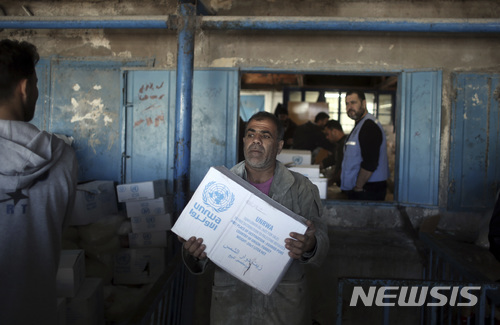 【가자시티=AP/뉴시스】14일(현지시간) 팔레스타인 가자시티의 샤티 난민캠프에서 한 난민이 유엔의 구호식품을 받고 있다. 2018.01.18.