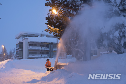 【다보스=AP/뉴시스】 스위스 다보스에서 세계경제포럼이 하루 앞으로 다가온 22일 눈이 가득 쌓인 차량 진입로 제설작업이 한창이다. 2018. 1. 22.