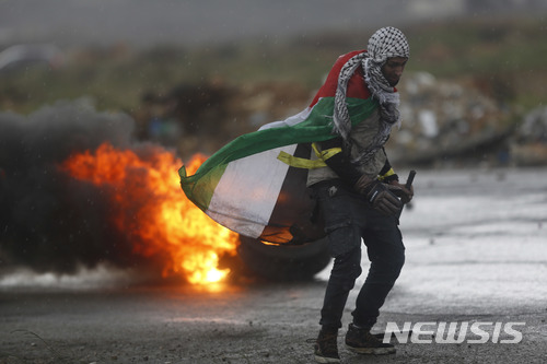 【서안지구=AP/뉴시스】23일(현지시간) 팔레스타인 자치구역 서안지구에서 팔레스타인 시위자가 이스라엘군에 맞서고 있다. 2018.1.24.