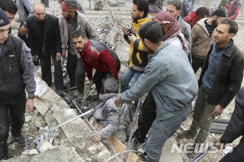 【다마스쿠스=AP/뉴시스】5일(현지시간) 시리아 다마스쿠스의 정부군 공습 현장에서 구조대가 잔해에 깔린 남성을 구출하고 있다. 사진은 시리아민방위대(SCD) 제공. 2018.2.21.