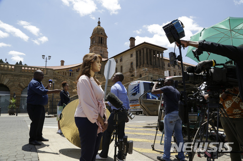 Various news organisations go live on camera outside the presidents office, background, at the government&#039;s Union Buildings in Pretoria, South Africa, Wednesday, Feb. 14, 2018. The nation is waiting to hear whether President Jacob Zuma will obey a ruling party order to quit due to scandals linked to him. (AP Photo/Themba Hadebe)