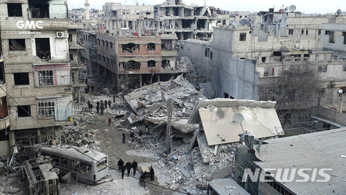 【다마스쿠스( 시리아) = AP/뉴시스】시리아의 반정부 단체 구타 미디어 센터가 제공한 22일 동구타 시내의 풍경. 정부군의 포격과 공습으로 부서진 건물들 사이에서 사람들이 시신을 운반하고 있다. 세계 각국 지도자들과 유엔 구호기관은 이 지역에 대해 즉각 전투중지 명령을 내리도록 유엔안보리에 촉구하고 있다.  