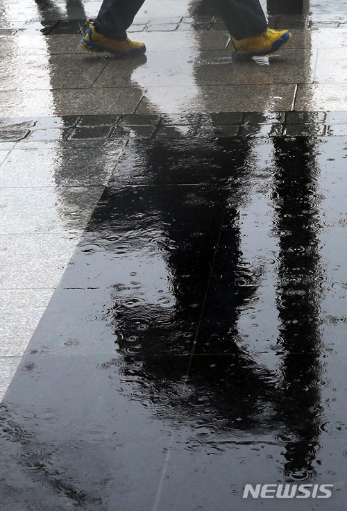 【서울=뉴시스】조성봉 기자 = 전국적으로 비가 내린 28일 오후 서울 종로구 광화문 네거리에서 우산을 쓴 시민의 모습이 빗물에 비춰보이고 있다. 2018.02.28.suncho21@newsis.com