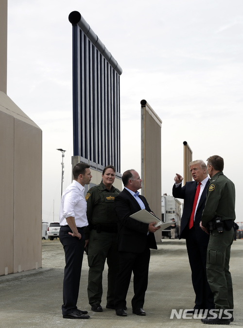 【샌디에이고=AP/뉴시스】 도널드 트럼프 미국 대통령이 13일(현지시간) 캘리포니아주 샌디에이고를 방문해 국경장벽 모델들을 살펴보면서 관계자와 대화하고 있다. 2018.3. 14 