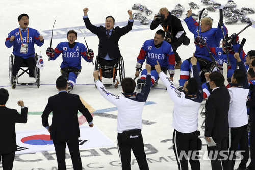South Korean players and team officials celebrate winning the bronze medal Ice Hockey match against Italy at the 2018 Winter Paralympics at the Gangneung Hockey Center in Gangneung, South Korea, Saturday, March 17, 2018. (AP Photo/Ng Han Guan)