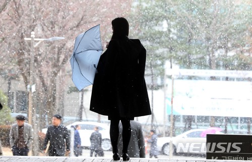 【서울=뉴시스】조성봉 기자 = 눈이 내리는 21일 오후 서울 서초구의 한 거리에서 시민이 우산을 펼치고 있다. 2018.03.21. suncho21@newsis.com