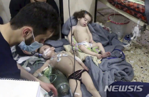 【두마=AP/뉴시스】 시리아 민간구호단체 화이트 헬멧이 제공한 사진으로, 8일 의료진이 전날 저녁 동구타의 두마에 저질러진 독가스의 화학무기 공격 피해 유아들을 돌보고 있다. 40명에서 최대 70명이 사망한 것으로 보이며 시리아 정부군 소행으로 여겨지고 있다. 2018. 4. 8. 
