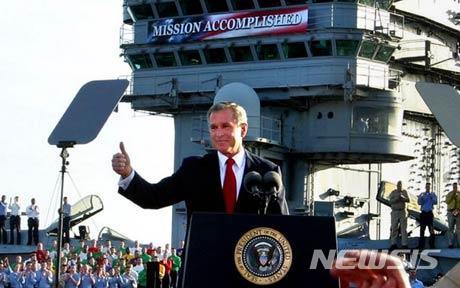 【서울=뉴시스】 조지 W.부시 대통령이 2003년 5월1일(현지시간) 에이브러햄 링컨 USS 항공모함에서 이라크전 공식 종료를 선언하고 있다. 그의 머리 위로 '임무 완료(Mission Accomplished)'라고 적힌 현수막이 걸려있다. (사진출처: AP) 2018.04.15. 