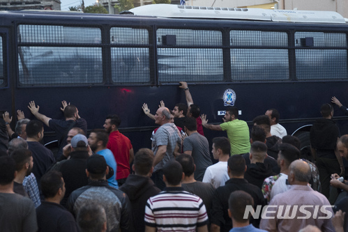 【레스보스섬(그리스)=AP/뉴시스】그리스 레스보스섬에서 3일(현지시간) 유럽연합(EU)의 난민 정책에 항의하는 난민 시위대가 경찰 버스를 밀어 넘어뜨리려 하고 있다. 그리스 경찰은 이날 최루가스와 섬광탄을 발사하며 시위대를 해산시켰다. 부상자는 발생하지 않았다. 하지만 지난달 30일에는 독일에서 난민들이 경찰을 공격해 추방을 앞둔 난민 남성을 탈출시키는 등 난민들과 경찰 간 충돌이 확산되고 있다. 2018.5.4