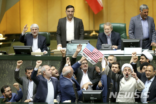【테헤란(이란)=AP/뉴시스】이란 국회의원들이 9일 테헤란의 국회의사당에서 미국의 이란 핵협정 탈퇴를 비난하며 종이로 만든 미 성조기를 불태우고 있다. 이들은 "미국에 죽음을"이라는 구호를 외치며 미국에 항의하는 즉석 시위를 벌였다. 2018.5.9 