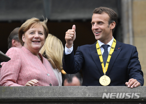 【아헨=AP/뉴시스】앙겔라 메르켈 독일 총리(왼쪽)과 에마뉘엘 마크롱 독일 대통령이 10일(현지시간) 독일 아헨에서 열린 사를마뉴상(유럽 통합에 기여한 인물에 수여) 시상식에 참석했다. 이날 수상자는 마크롱 대통령이다. 2018.5.11.