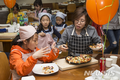 【서울=뉴시스】 = 현대엔지니어링 임직원 가족들이 지난 12일 열린 사내 행사에서 직접 만든 피자를 접시에 담아 나누고 있다. (사진제공=현대엔지니어링)