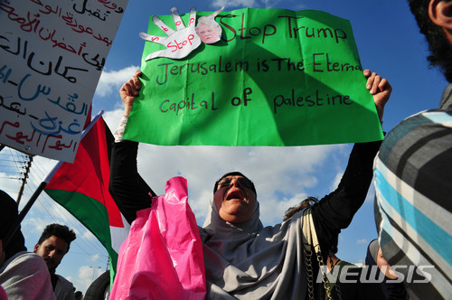 【암만(요르단)=뉴시스】 채정병 기자 = 14일(현지시간) 이스라엘 미국 대사관의 예루살렘 이전을 규탄하는 시위가 주 요르단 미국 대사관 인근에서 열린 가운데 한 여성이 "예루살렘은 팔레스타인의 영원한 수도'라고 쓴 문구를 들고 구호를 외치고 있다. 시위대의 대다수를 차지한 팔레스타인 출신들은 70년 전 오늘, 이스라엘에 나라를 빼앗긴 국치일(알 나크바)에 맞춰 대사관 이전을 승인한 트럼프의 행태에 분노하며 복수를 외쳤다.요르단 강을 경계로 이스라엘과 접해 있는 요르단은 1948년 이스라엘에 의해 강제로 쫓겨 나온 팔레스타인 실향민들이 전체 인구의 60% 이상을 차지하고 있어 예루살렘의 이스라엘의 수도 선언과 함께 대사관을 옮긴 미국의 조치는 이들을 격분케 하고 있다.  2018.05.15chae0191@newsis.com