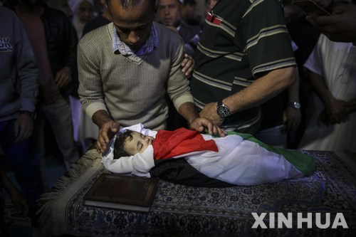 【가자=신화/뉴시스】15일(현지시간) 팔레스타인 가자지구에서 이스라엘군이 발사한 최루가스를 흡입해 사망한 생후 8개월 된 라일라 알-간두르의 장례식이 진행되고 있다. 아기의 몸이 팔레스타인 자치정부 국기로 감싸여 있다. 척 등 추모객들이 간두르에게 마지막 인사를 하고 있다. 가족들은 하루 전 14일 예루살렘 미국대사관 반대 시위 현장에서 라일라가 이스라엘군이 쏜 최루가스를 마시고 사망했다고 주장하고 있다. 2018.5.16