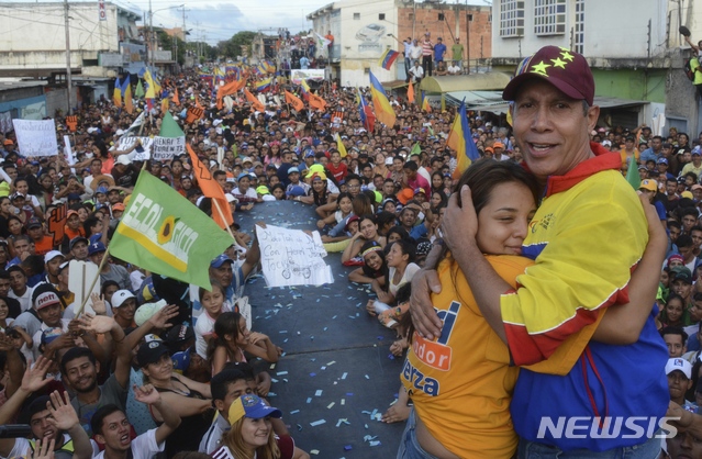 【바르키시메토( 베네수엘라)= AP/뉴시스】 2018년 5월 17일 대통령 선거일을 사흘 앞두고 선거유세중 지지자들의 포옹을 받고 있는 엔리 팔콘. 