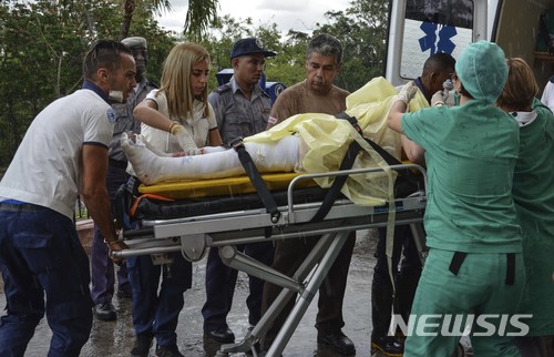 【아바나=AP/뉴시스】18일(현지시간) 쿠바 구조대원들이 여객기 추락 사고 현장에서 발견된 생존자 한명을 구급차에 옮기고 있다. 이번 사고로 107명이 숨지고, 생존자 3명도 위독한 것으로 알려졌다. 승객 104명과 승무원 6명을 태운 쿠바 국영 항공사 소속 보잉 737 항공기(편명 CU972)가 18일 수도 아바나 호세 마르티 국제공항에서 이륙한 직후 추락했다. 2018.05.19 