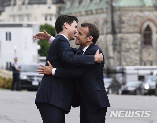 【오타와=AP/뉴시스】쥐스탱 트뤼도 캐나다 총리(왼쪽)가 캐나다 오타와를 찾은 에마뉘엘 마크롱 프랑스 대통령을 포옹으로 환영하고 있다. 2018.06.07