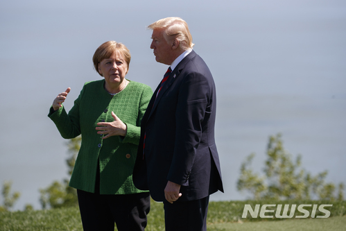 【샤를브와(캐나다)=AP/뉴시스】앙겔라 메르켈 독일 총리가 지난 8일 캐나다 샤를브와에서 열린 주요 7개국(G7) 정상회담 단체사진을 찍은 후 도널드 트럼프 미 대통령과 이야기를 나누고 있다. 메르켈 총리는 10일 독일 공영 TV와의 인터뷰에서 트럼프 대통령이 G7 정상회담 발표 공동성명을 승인하지 않겠다고 밝힌 것에 대해 "정신이 번쩍 들게 만들었고 다소 실망했다"고 말했다. 2018.6.11