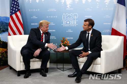 【퀘벡=AP/뉴시스】도널드 트럼프 미국 대통령(왼쪽)과 에마뉘엘 마크롱 프랑스 대통령이 8일(현지시간) 주요 7개국(G7) 정상회의가 열리는 캐나다 퀘벡에서 만나 악수를 하기 위해 손을 내밀고 있다. 2018.06.11