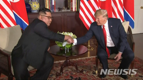 【싱가포르=AP/뉴시스】 김정은 북한 국무위원장과 도널드 트럼프 미국대통령이 12일 싱가포르 카펠라 호텔에서 처음 만나 악수하고 있다. 사진은 동영상을 캡처한 것이다. 2018.06.12 