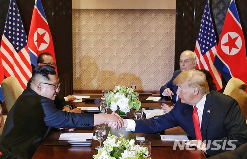 【싱가포르=AP/뉴시스】도널드 트럼프 미 대통령(오른쪽)과 김정은 북한 국무위원장이 12일 싱가포르 카펠라 호텔에서 사상 첫 북미 정상회담 확대 회담을 시작하면서 악수를 나누고 있다. 2018.6.12 