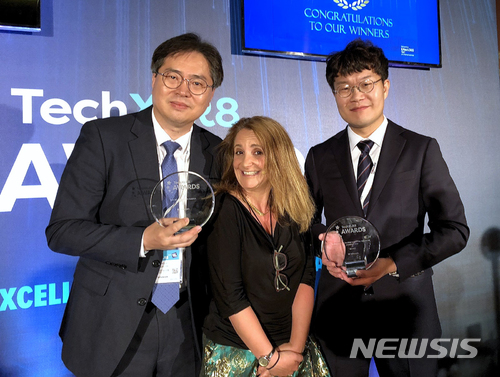 【서울=뉴시스】 SK텔레콤이 혁신적인 5G 기술을 앞세워 세계적 권위의 글로벌 ICT 어워드 ‘TechXLR8 2018’에서 ‘최우수 네트워크 사업자(Best Network Development of the Year Award)’에 선정되는 등 2개 부문에서 수상했다고 13일 밝혔다. 사진은 12일(현지시간) 영국 런던에서 열린 ‘TechXLR8 2018’ 시상식 후 SK텔레콤 조성호 Access Network 랩장(왼쪽)과 이동기 박사(오른쪽)가 사회자와 기념촬영을 하고 있는 모습. 2018.06.13. (사진=SK텔레콤 제공) photo@newsis.com