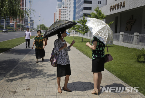 【평양=AP/뉴시스】 18일 북한 평양 미래 과학로 인도에서 양산 쓴 두 여성이 이야기하고 있다. 2018. 6. 18. 