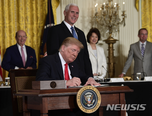 【워싱턴=AP/뉴시스】도널드 트럼프 미 대통령이 18일 마이크 펜스 부통령이 지켜보는 가운데 백악관 이스트룸에서 국가우주위원회 회의 중 우주정책지시서에 서명하고 있다. 트럼프 대통령은 이날 우주군 창설을 지시했다. 2018.6.19 