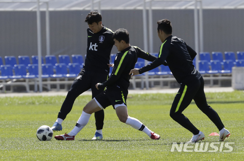 South Korea&#039;s Son Heung-min, left, goes for the ball with Ju Se-jong, center, and Moon Seon-min, right, during a training session of South Korea at the 2018 soccer World Cup at the Spartak Stadium in Lomonosov near St. Petersburg, Russia, Wednesday, June 20, 2018. (AP Photo/Lee Jin-man)