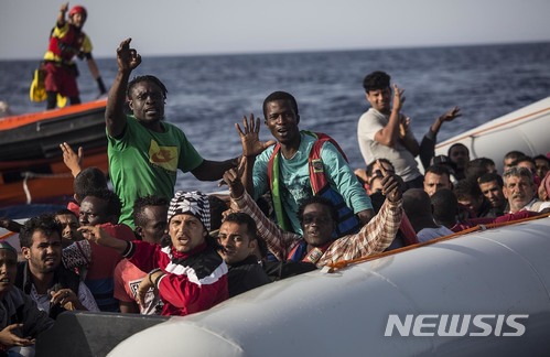 【리비아=AP/뉴시스】30일(현지시간) 리비아 해안에서 고무 보트에 탄 난민들이 구조를 요청하고 있다. 2018.6.30. 