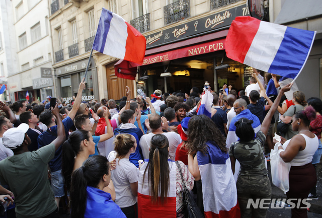 【파리=AP/뉴시스】15일(현지시간) 프랑스와 크로아티아 간 2018 러시아 월드컵 결승전에서 프랑스가 4-2로 승리해 1998년 프랑스 월드컵 이후 2번째 우승이 확정되자 수도 파리에 쏟아져나온 프랑스 축구팬들이 프랑스 국기글 흔들며 열광하고 있다. 2018.7.16 