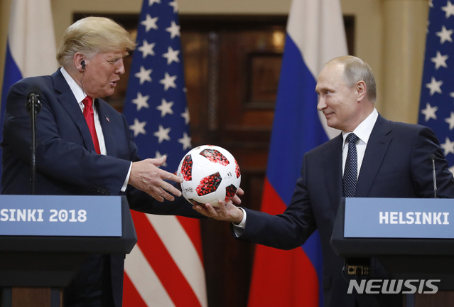 【헬싱키=AP/뉴시스】도널드 트럼프 미국 대통령이 16일(현지시간) 핀란드 헬싱키에서 열린 기자회견에서 블라디미르 푸틴 러시아 대통령으로부터 월드컵 축구공을 선물로 받고 있다. 2018.07.17 