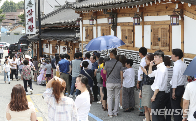 【서울=뉴시스】최진석 기자 = 초복날인 17일 서울 종로구 한 삼계탕 음식점 앞에서 시민들이 길게 줄지어 서 입장을 기다리고 있다. 2018.07.17. myjs@newsis.com