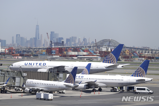 FILE- In this May 2, 2018, file photo, the New York City skyline is seen at a distance as United Airlines jets sit at gates at Newark Liberty International Airport in Newark, N.J. United Continental Holdings, Inc. reports earnings Tuesday, July 17, 2018. (AP Photo/Julio Cortez, File) 