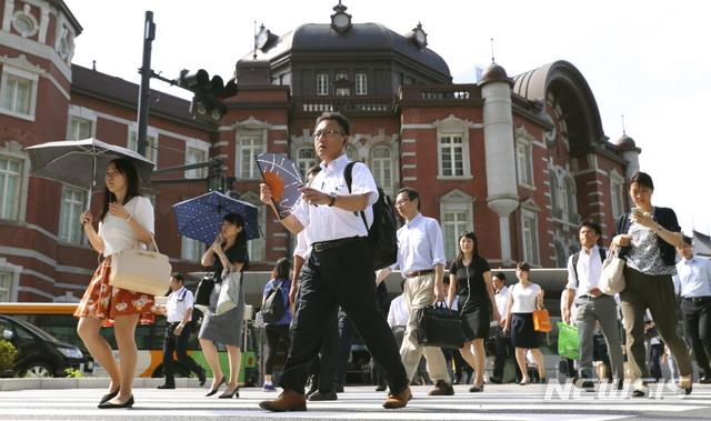 【도쿄=AP/뉴시스】폭염이 계속되는 일본에서 20일 양산과 부채를 손에 든 시민들이 도쿄역 앞을 지나가고 있다.2018.7.26. 