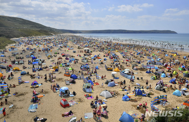 【노쓰 데번=AP/뉴시스】 5일 영국 잉글랜드 남서부의 울에콤브 해변에서 사람들이 해수욕을 즐기고 있다. 영국에도 유럽 대륙의 뜨거운 공기가 계속 위세를 부리고 있으나 열파 단계는 아니고 30도 초반의 '이상 고온'에 매우 가물다. 2018. 8. 5.