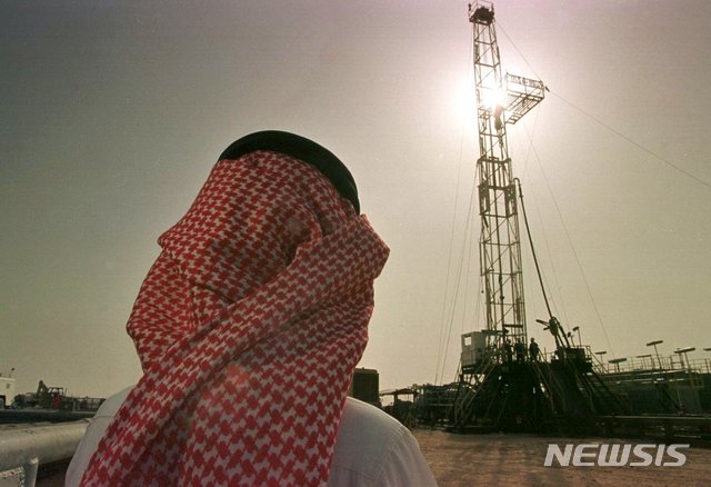 【호우타(사우디아라비아)=AP/뉴시스】지난 1997년 2월26일 사우디아라비아 호우타의 알-호우타 유전에서 사우디 국영석유회사 아람코의 한 직원이 원유 채굴 작업을 지켜보고 있다. 할리드 알-팔리 사우디 에너지장관은 23일 아람코의 상장 계획이 취소됐다는 보도와 관련해 아람코 상장은 반드시 이뤄질 것이라고 다짐했다. 2018.8.23