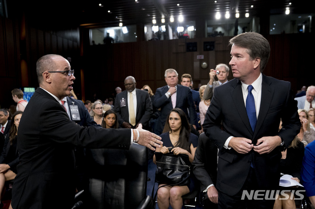 Fred Guttenberg, the father of Jamie Guttenberg who was killed in the Stoneman Douglas High School shooting in Parkland, Fla., left, attempts to shake hands with President Donald Trump&#039;s Supreme Court nominee, Brett Kavanaugh, right, as he leaves for a lunch break while appearing before the Senate Judiciary Committee on Capitol Hill in Washington, Tuesday, Sept. 4, 2018, to begin his confirmation to replace retired Justice Anthony Kennedy. Kavanaugh did not shake his hand. (AP Photo/Andrew Harnik)