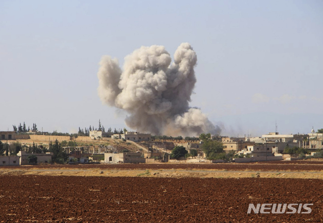 【호베이트=AP/뉴시스】 시리아 민간방위 조직 화이트헬멧 제공 사진으로, 10일 반군이 집결해 있는 이들립시 인근 마을에 시리아 정부군이 공습을 가해 연기가 솟아오르고 있다. 2018. 9. 11  