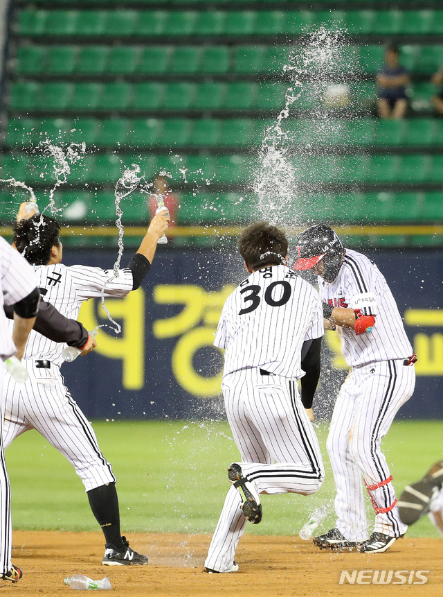 【서울=뉴시스】 김선웅 기자 = 12일 서울 송파구 잠실야구장에서 열린 2018 KBO 리그 LG 트윈스와 넥센 히어로즈의 경기, 10회말 1사 주자 만루 4:4 동점상황 LG 정주현이 끝내기 안타를 날리고 동료들에게 축하를 받고 있다. 5:4로 LG 트윈스 승리. 2018.09.12.mangusta@newsis.com