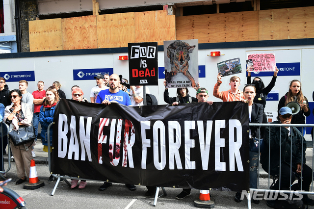 【런던 = AP/뉴시스】 런던 패션위크 행사장 밖에서 동물보호운동 시위대가 16일(현지시간) 베컴을 비난하면서 모피사용 금지법을 촉구하는 구호를 외치고 있다. 