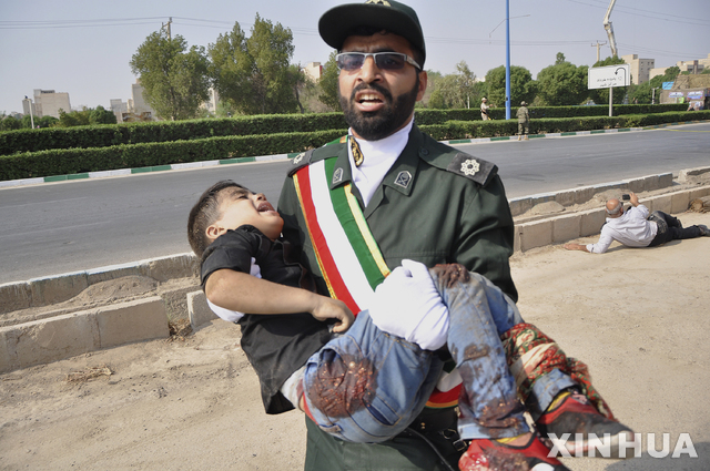 【아흐바즈(이란) = AP/뉴시스】 군사행렬에 가해진 테러 공격으로 총상을 입은 어린이를 운반하는 이란군인.  